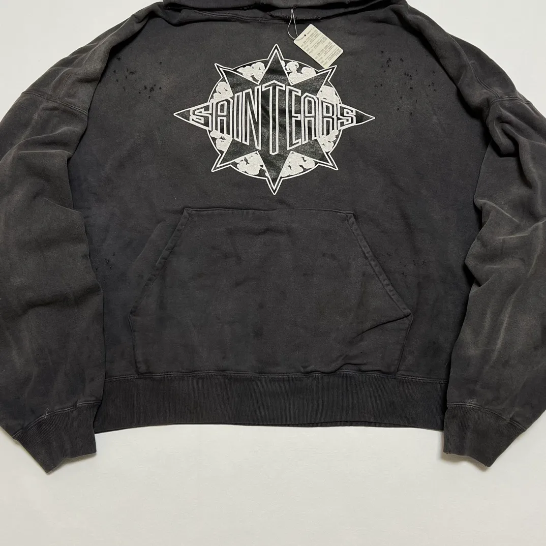 DENIM TEARS x SAINT Mxxxxxx SAINT TEARS Hoodie/BLK Five-pointed star cotton hole-in-the-dark distressed hoodie, washed black S-XL Assute dyeing, whole piece sprayed with horse fade/horse weight, co-branded main mark/cotton wash mark/cherub mark, many hanging holes on the front and rear panels, the original version has the same loose fit